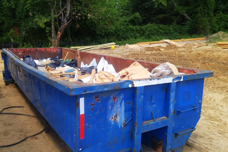 Large blue Roll on roll off commercial skip on site in Swansea with constrction waste and rubble